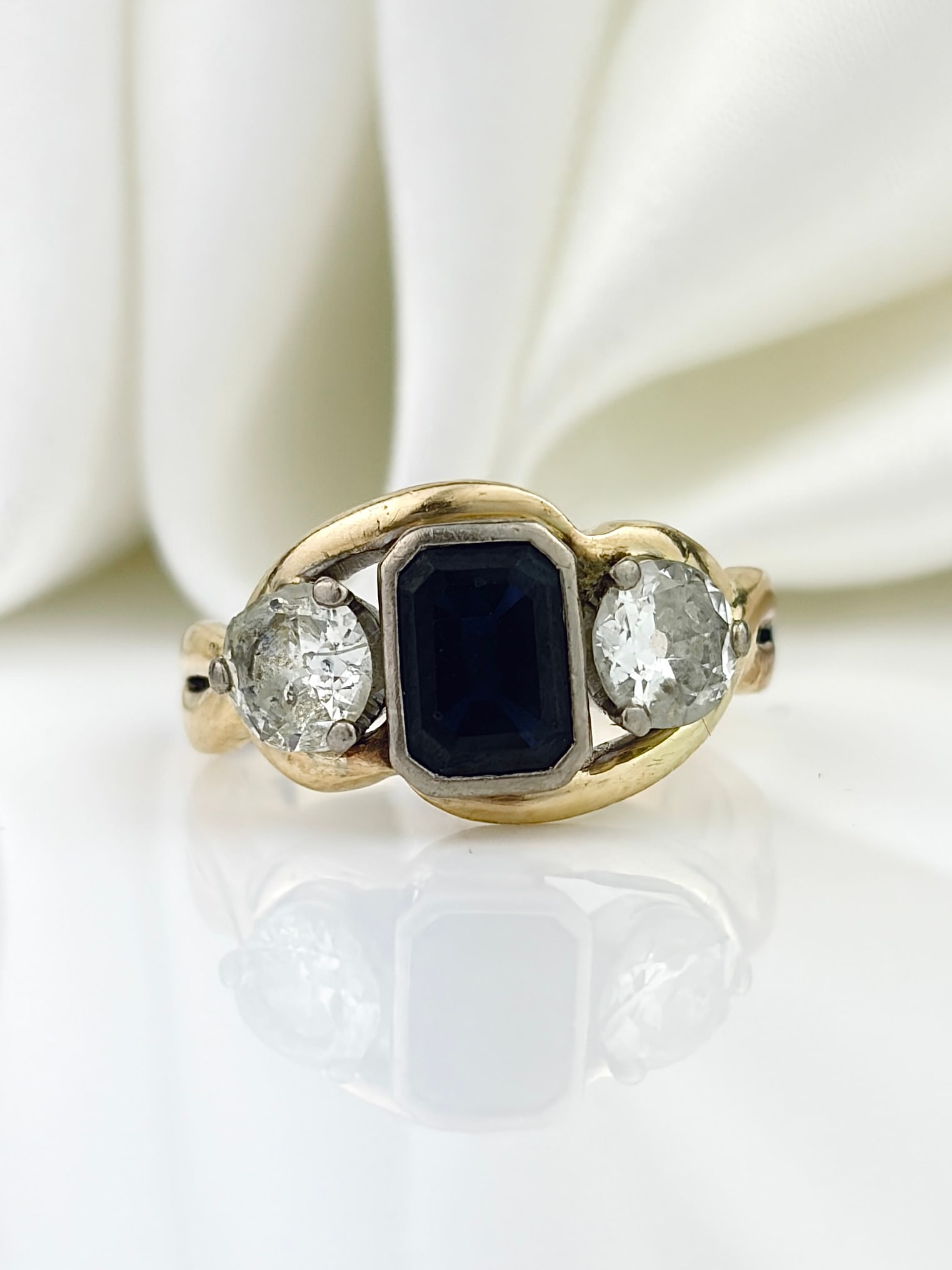VINTAGE 14CT YELLOW GOLD SAPPHIRE AND DIAMOND 3 STONE TWIST RING: VINTAGE 14CT YELLOW GOLD SAPPHIRE AND DIAMOND 3 STONE TWIST RING Beautiful ring with a twisted shank detail that holds two .50pt diamonds and a central sapphire!