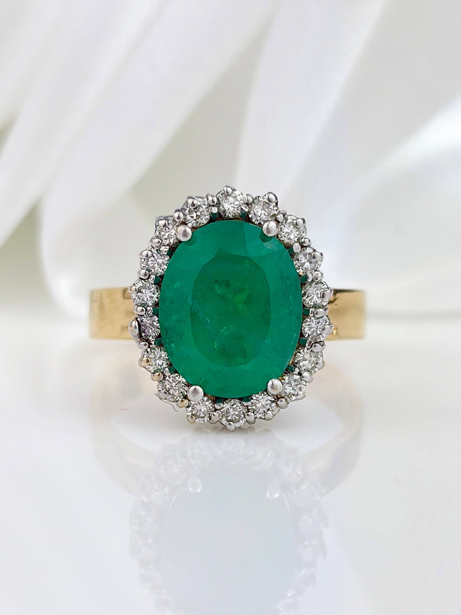 AMAZING 18CT YELLOW GOLD EMERALD AND DIAMOND CLUSTER RING: AMAZING 18CT YELLOW GOLD EMERALD AND DIAMOND CLUSTER RING Incredible large cluster ring featuring a giant bright green emerald, surrounded by a halo of diamonds! Weight: 7.63g Size: UK R, US