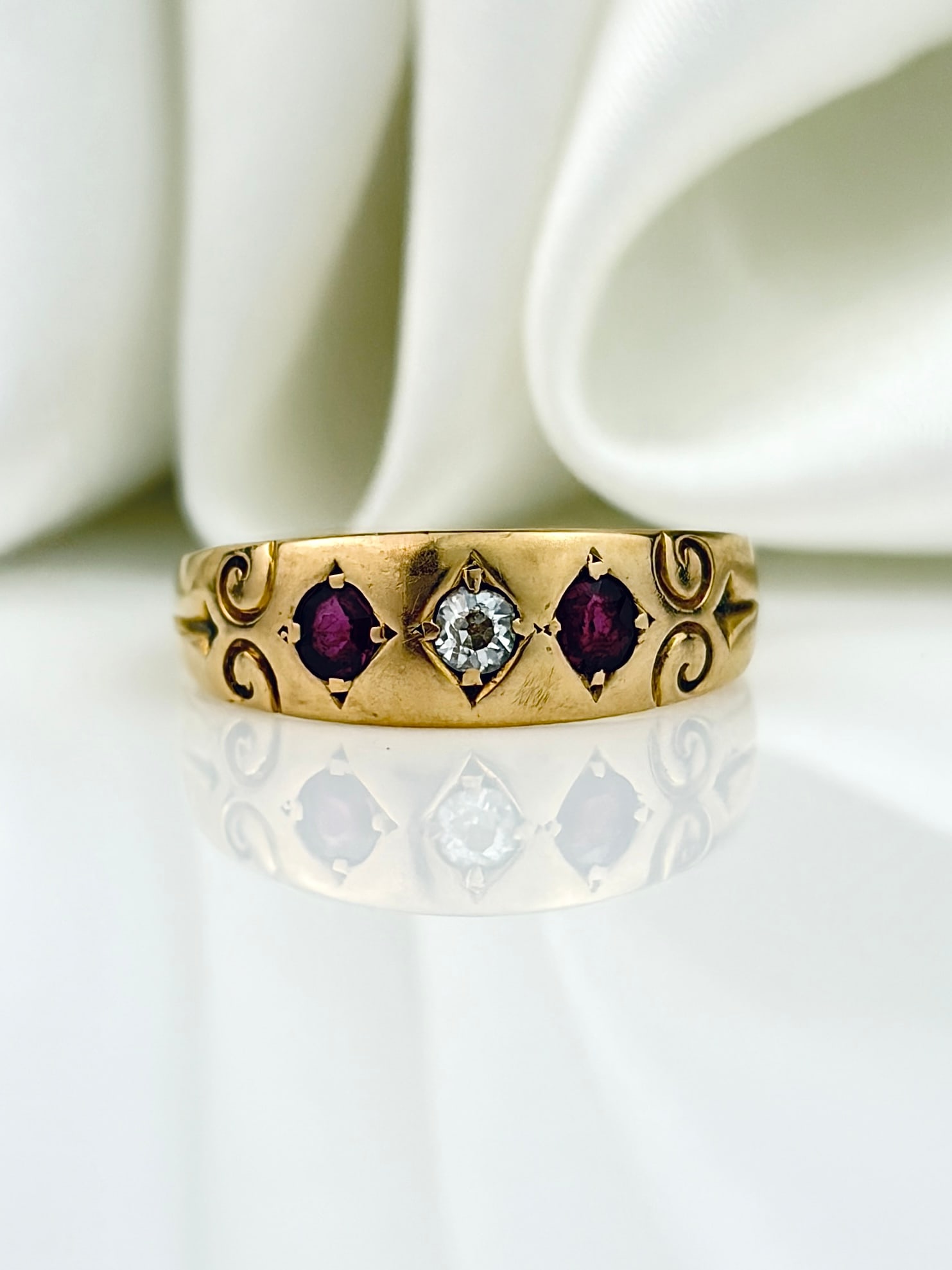 LOVELY ANTIQUE 18CT YELLOW GOLD RUBY AND DIAMOND 3 STONE RING: LOVELY ANTIQUE 18CT YELLOW GOLD RUBY AND DIAMOND 3 STONE RING A gorgeous wide band featuring a central diamond flanked by two rubies, with swirl detail shoulders!