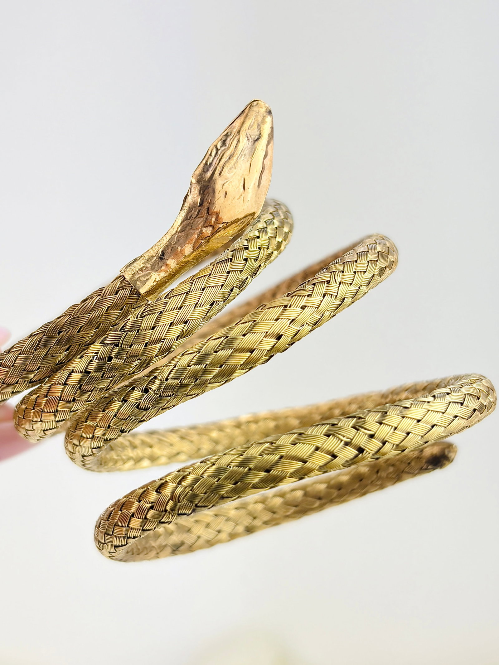 Coiled Snake Bangle in Gilt Metal: Coiled Snake Bangle in Gilt Metal Weight: 17.45g Size: Expands, 38x38mm Inside Materials: Silver Gilt Hallmarks: None present Condition: The overall condition is very good Office Use: QZZ