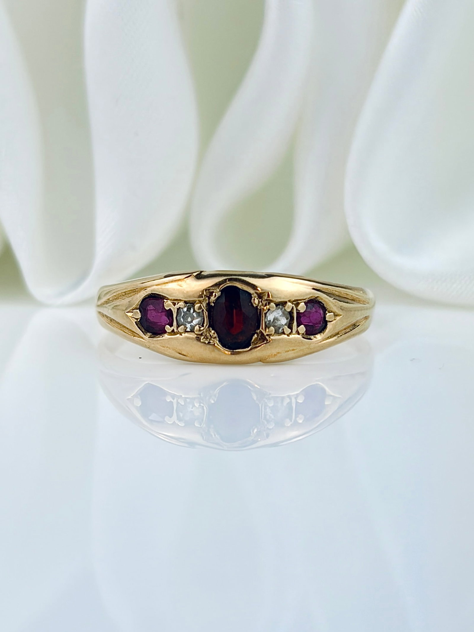 ANTIQUE 18CT YELLOW GOLD GARNET, RUBY AND DIAMOND 5 STONE RING: ANTIQUE 18CT YELLOW GOLD GARNET, RUBY AND DIAMOND 5 STONE RING Wonderful ring with a garnet centre, and ruby outers, with a faded 1906 inscription. Weight: 2.36g Size: UK R, US 8.75, Width 5mm,