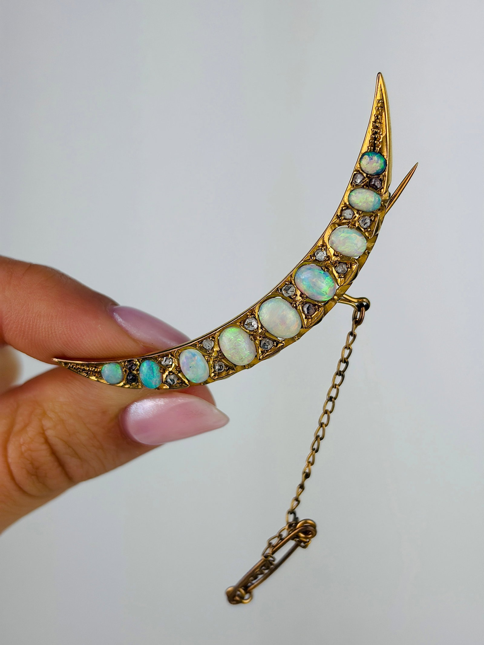Vintage Large Opal and Diamond 15ct Gold Crescent Brooch: Vintage Large Opal and Diamond 15ct Gold Crescent Brooch This exquisite brooch is set with 9 glowing opals that flash fiery red and so many other wonderful colours. In between each are a pair of lovel