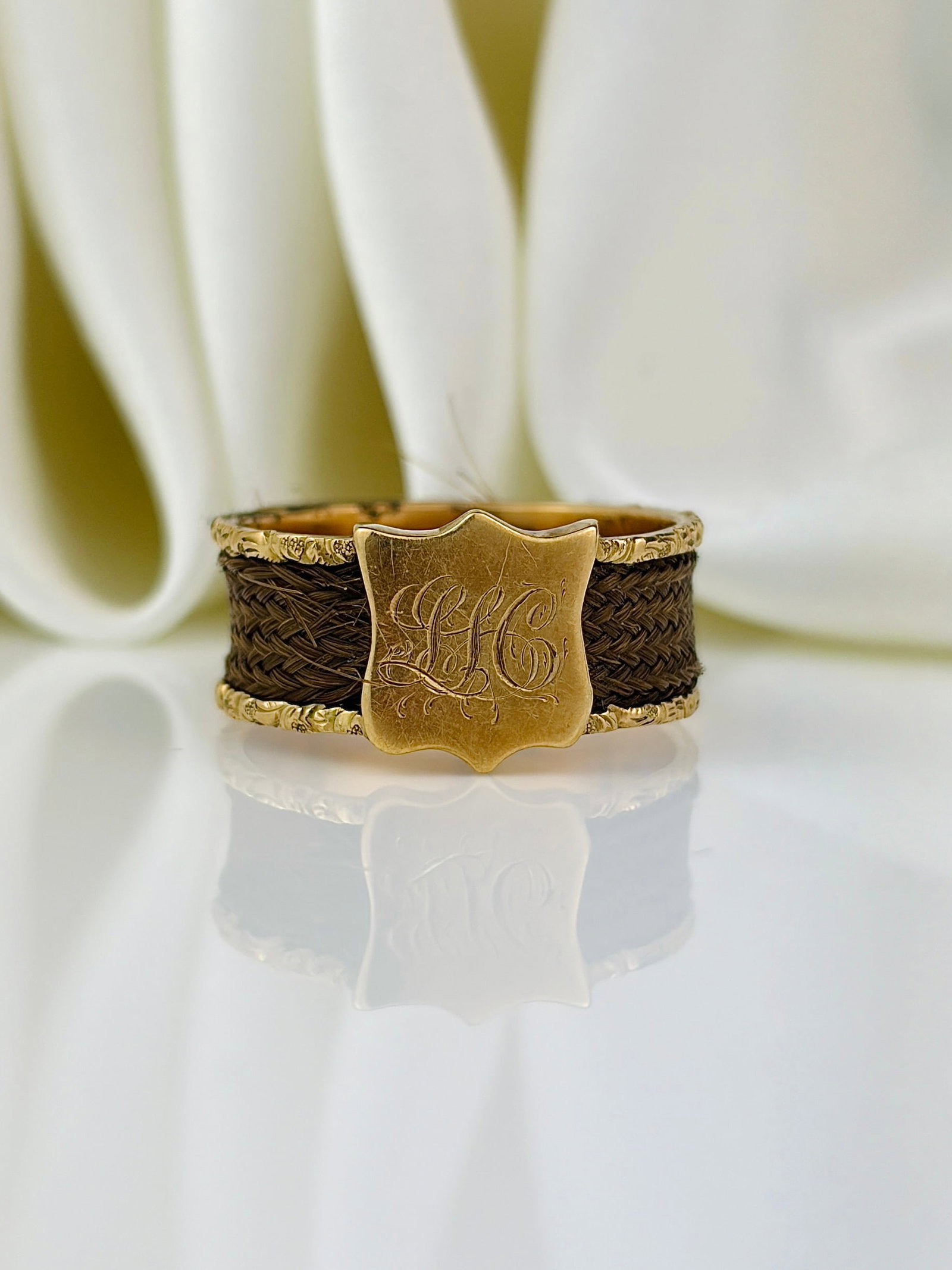 antique gold and hair 'LH' memorial wide band ring: antique gold and hair 'LH' memorial wide band ring Weight: 3.13g Size: UK N, US 7, Width 9mm, height off finger 1mm Materials: Gold Hallmarks: None present Condition: Good overall