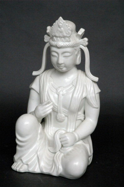 Fitz and Floyd Buddha Figure: Modeled in white porcelain as a seated Buddha or boddhisatva, impressed company logo. 12"H. Condition: excellent, no damage or repair.