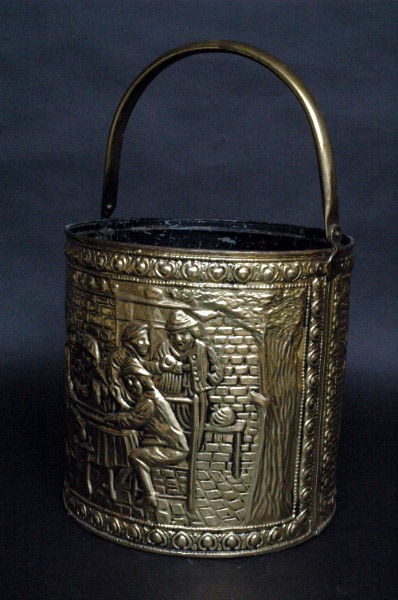 English Brass Bucket: With punched brass decoration depicting tavern scenes on recto and verso, hinged handle, the base stamped Made In England. 11"H (base to top of bucket). 11"D. Condition: some light scratches and wear,