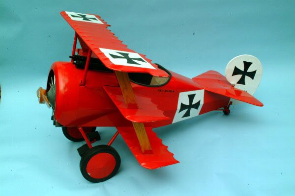 Red Baron Pedal Car, Modern: Red Baron Pedal Car, Modern Constructed from metal, wood, and paper as the infamous craft of the Red Baron, Manfred von Richthofen, legendary German WWI flying ace.33"H. 44"W. 57"L. Condition: small f