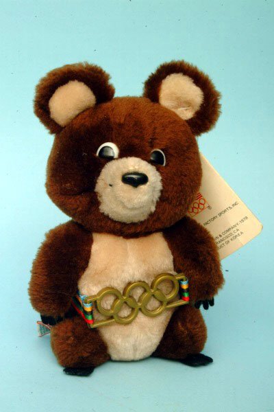 Misha 1980 Olympic Bear: Misha 1980 Olympic Bear The soft body covered in light and dark brown plush fur, wearing Olympic belt, with original tag affixed to ear and original R. Dakin tag. 8"L. Condition: excellent.