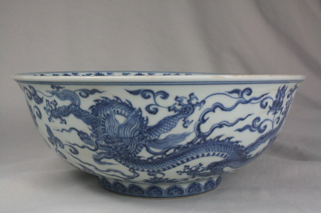 Chinese Blue and White Porcelain Bowl: A Chinese blue and white porcelain bowl, decorate with floral and dragon both in and out. Xuande mark. 4.2" x 11.2".
