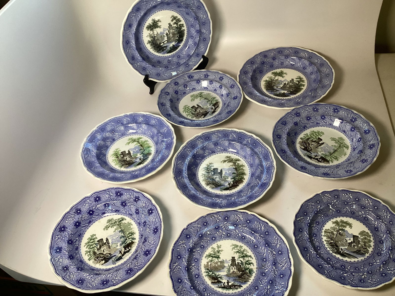 9 Pieces English DAVENPORT Polychrome Staffordshire Plates Bowls: Overall very good conditon; few with staining on bottoms. 1 plate with hairline. Pearlized finish. Largest plate is 10.5" wide. Includes 2 10.5" soups, 5 9.25" soups, 1 9.25" plate and 1 8.25" plate