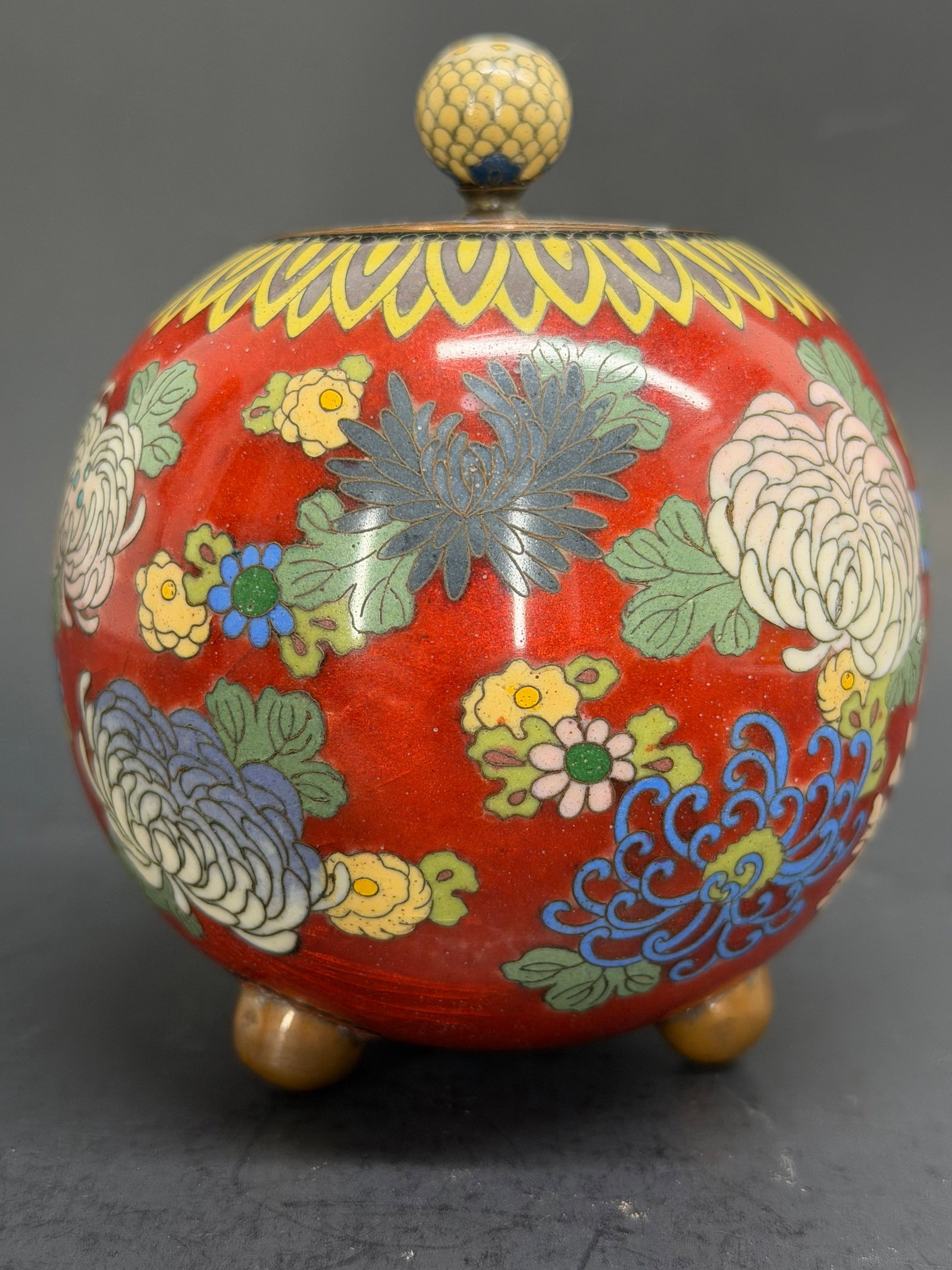 Japanese Meiji Period Cloisonne 4" Koro with Chrysanthemum and Peonies, lidded and footed ?? Unsigne: This lot features a Cloisonne on copper lidded Koro with a variety of multi colored Yusen Shippo Chrysanthemums and Peonies on a transparent red enamel base that really gives the appearance of floatin