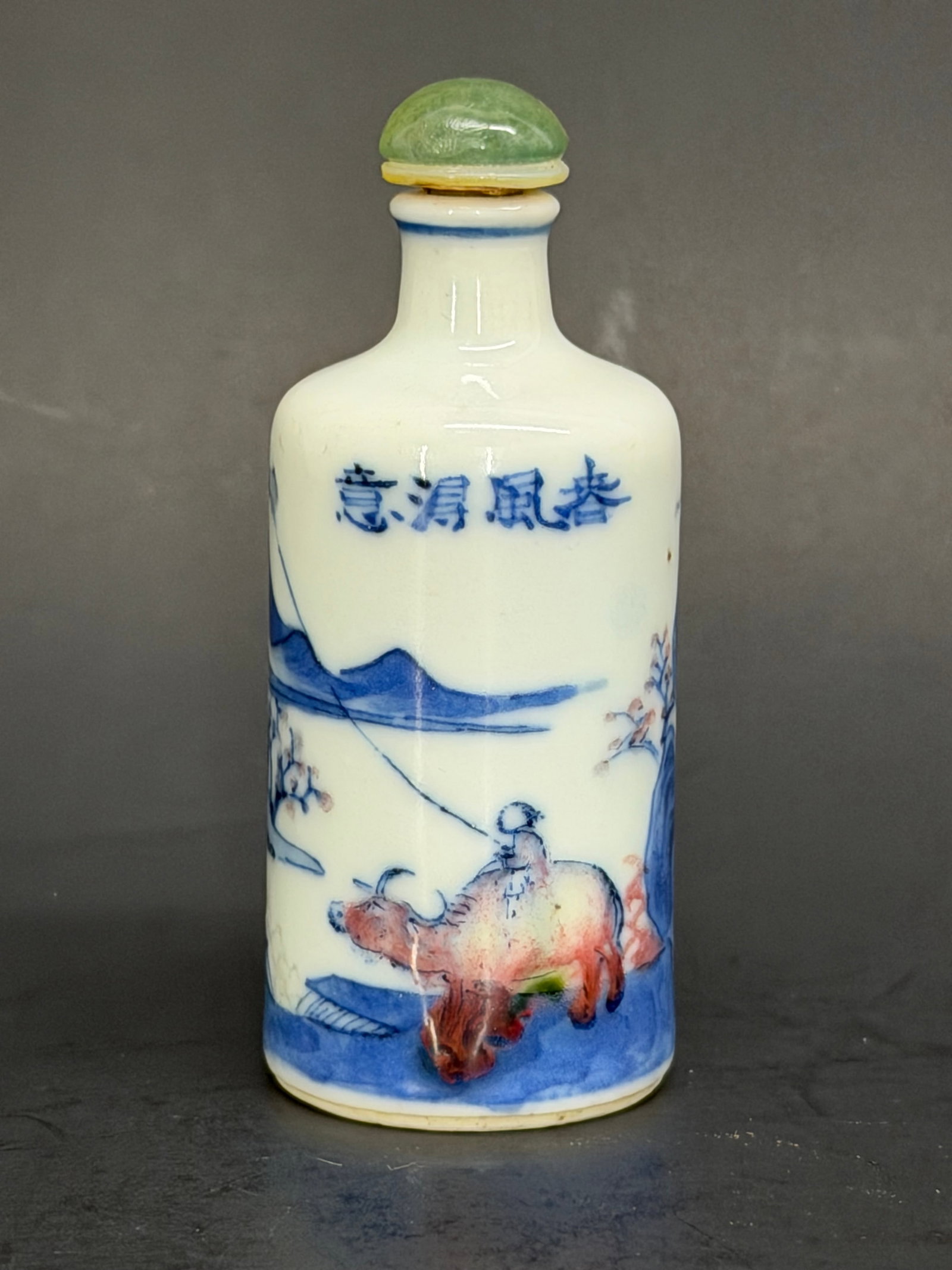 Chinese 19th Century Qing dynasty blue, white and iron red snuff bottle: Chinese 19th Century Qing dynasty blue, white and iron red snuff bottle depicting a landscape and a figure riding an ox flying a kite, Written on the bottle, “Those who care about the wind". A blue 