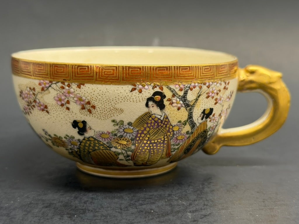 Japanese Meiji Period Satsuma Tea Cup Signed Kozan: Japanese Meiji Period Satsuma Tea Cup Signed Kozan depicting a mother and her child amongst flowers and cherry blossoms. 3 1/2'' in diameter by 1 3/4 deep.