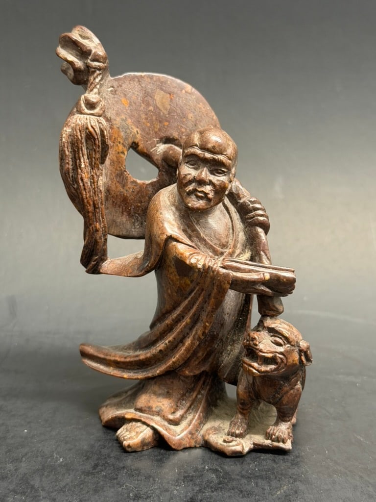 Chinese soapstone carving of Shou Lao- god of longevity: Beautifully carved Chinese soapstone carving of Shou Lao- god of longevity. Shown holding a scroll and staff and accompanied by a Shishi protector. 4'' tall by 2 1/2" by 1 3/4"