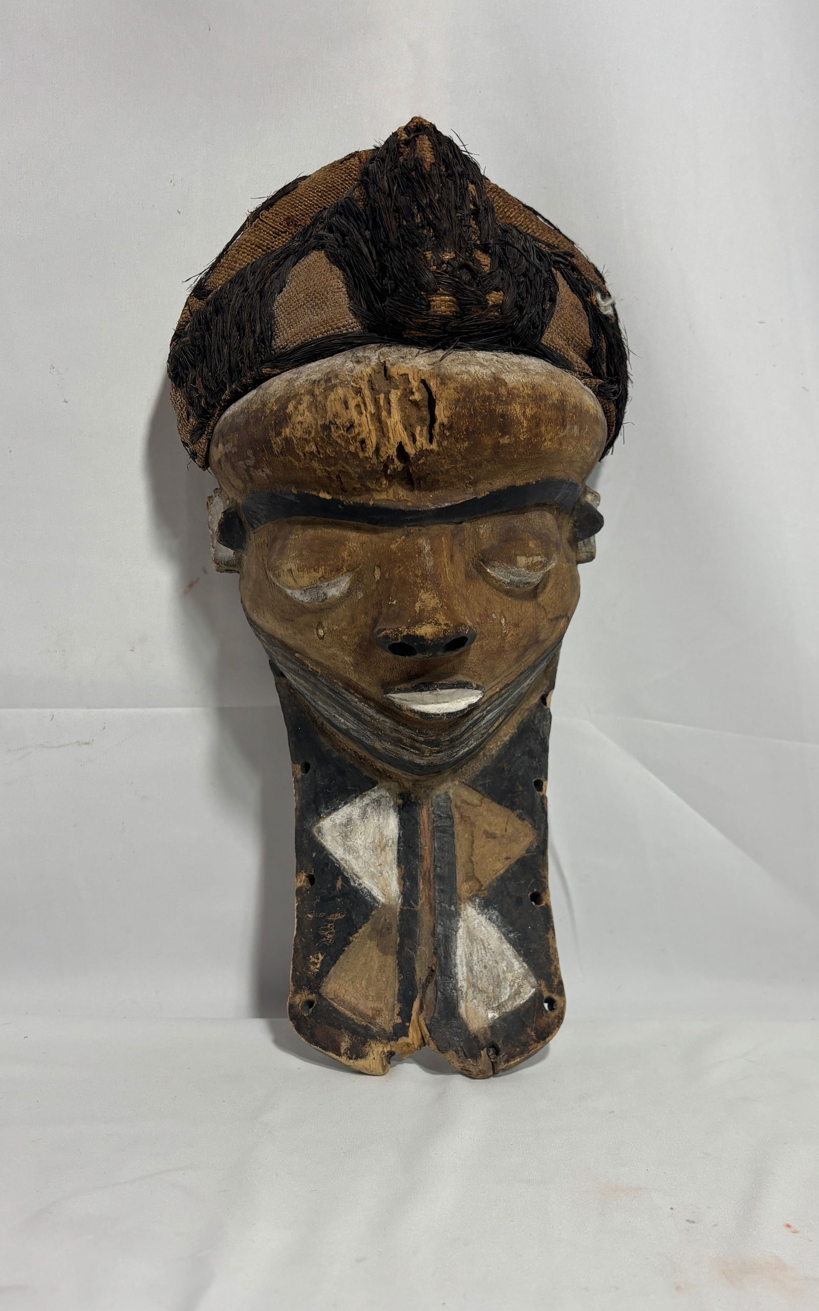 Zaire Pende Wood Bearded Mask: Zaire Pende Wood Bearded Mask – Rectangular beard, downcast eyes, fiber and pigments. This striking mask is a living symbol of Pende culture, deeply embedded in the traditions, beliefs, and social