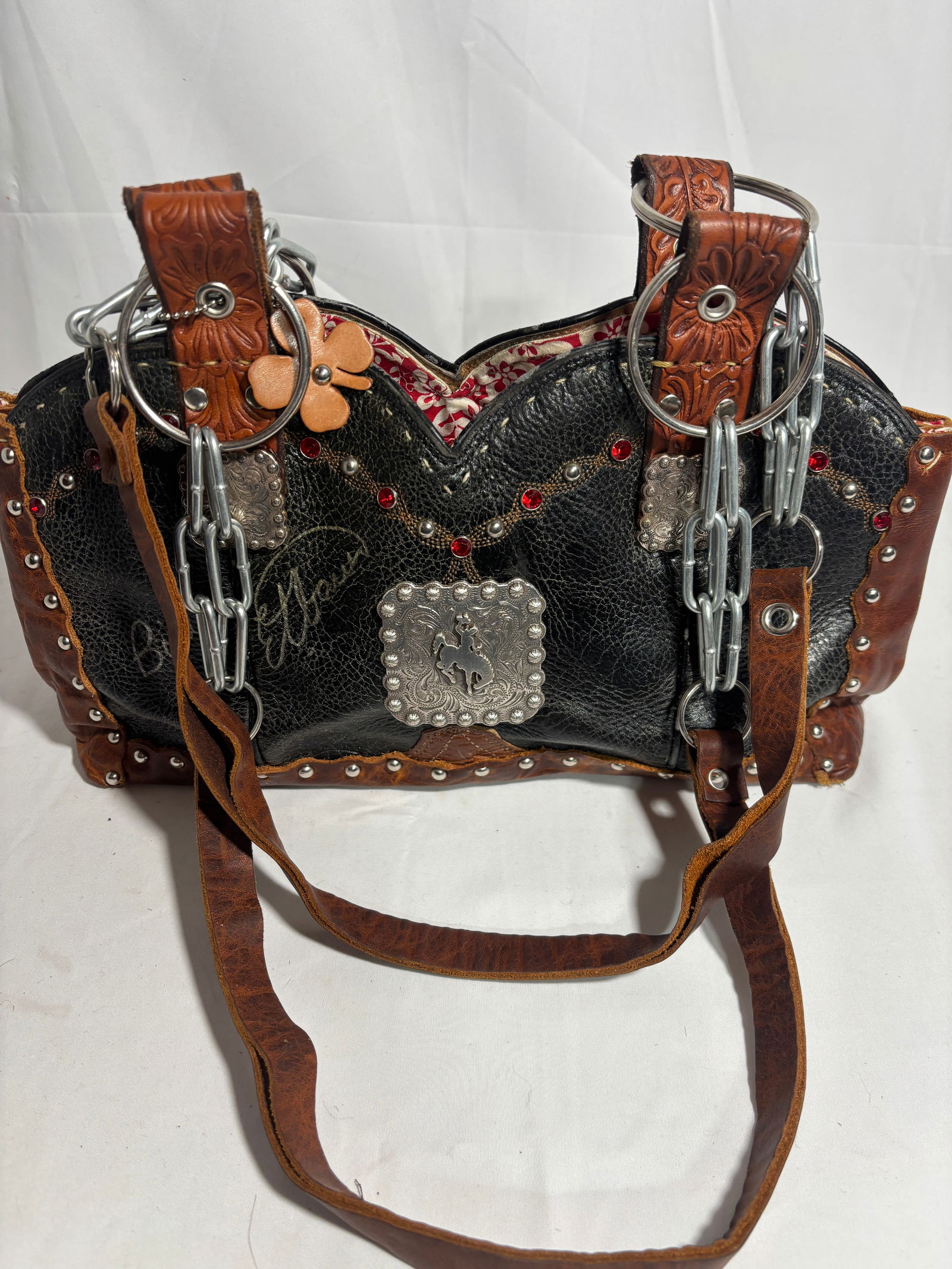Billy Ember Trail Cowboy Boot Purse: This vintage Western handbag is expertly crafted from authentic cowboy boot leather, highlighting a balance of rugged durability and refined craftsmanship. The double strap design allows for