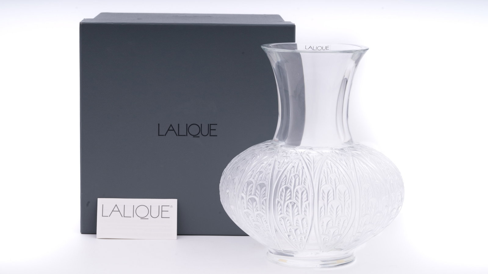 Lalique Thebes Vase French Art Glass: A contemporary Lalique "Thebes" vase, French crystal art glass featuring finely molded stylized palm leaf motifs in relief over a frosted lower body and a clear flared neck. Etched Lalique France mark