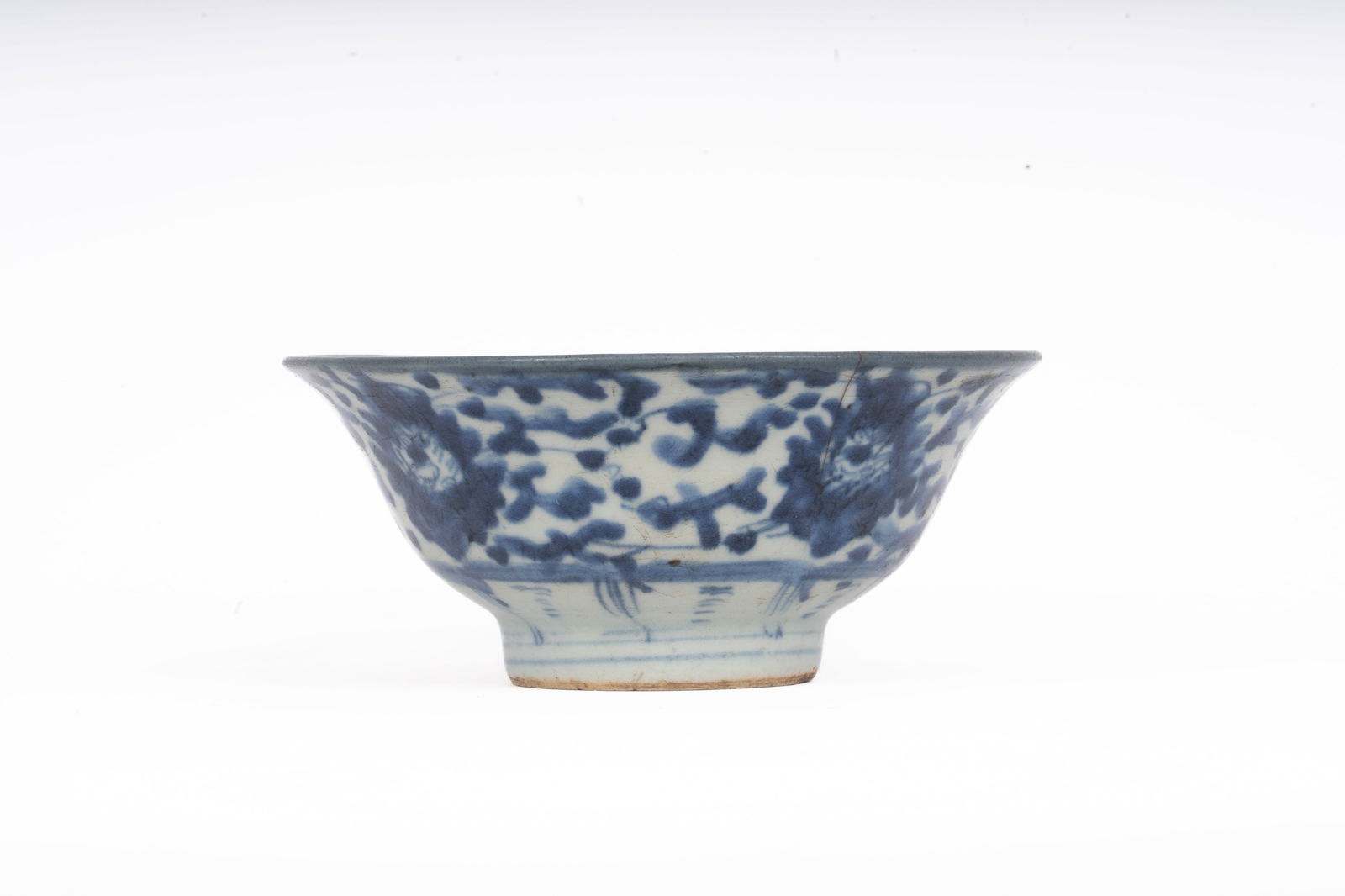Chinese Blue and White Porcelain Bowl, Early Qing Dynasty: A finely potted porcelain bowl decorated in underglaze blue with scrolling lotus and peony motifs between double line borders, the interior with a stylized central flower and banded rim design. The ba