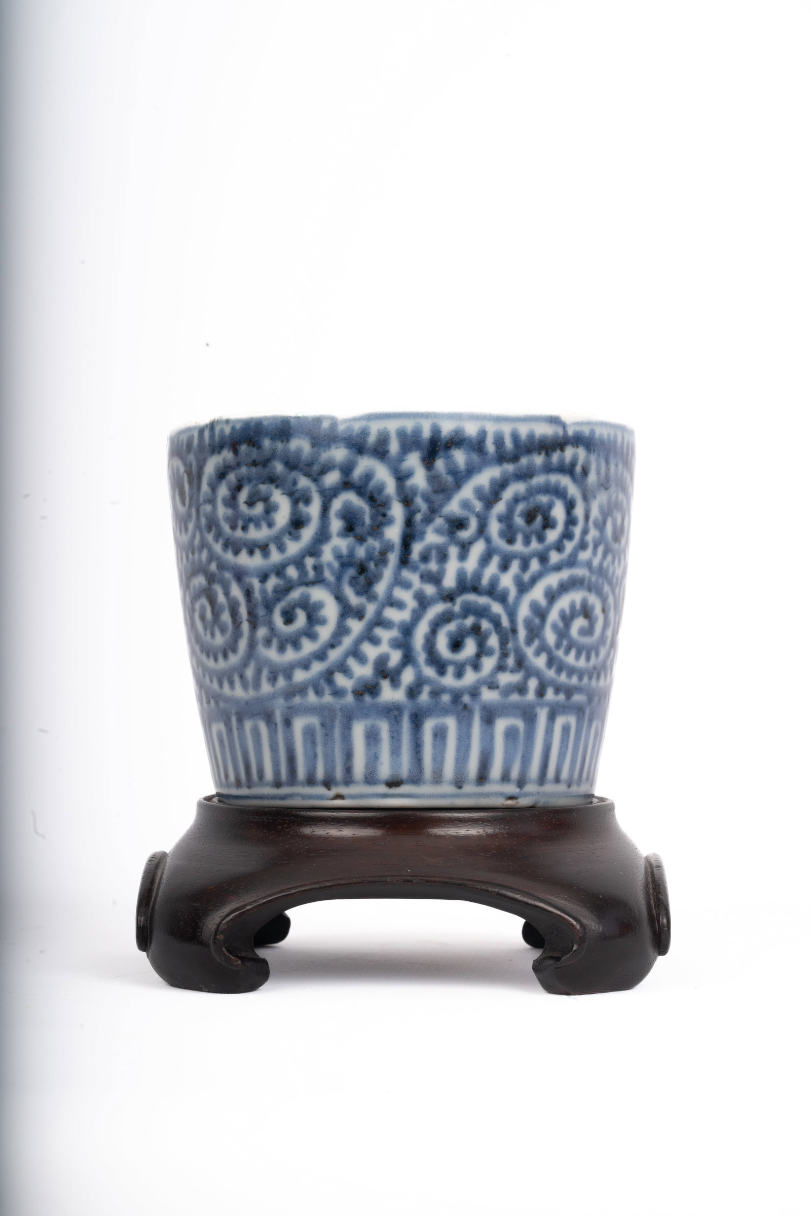 Chinese Blue and White Porcelain Cup, Kangxi Period: A finely potted porcelain cup with straight sides, painted in underglaze blue with a dense pattern of spiral scrolls above a lappet border, the interior decorated with a central roundel enclosing bamb