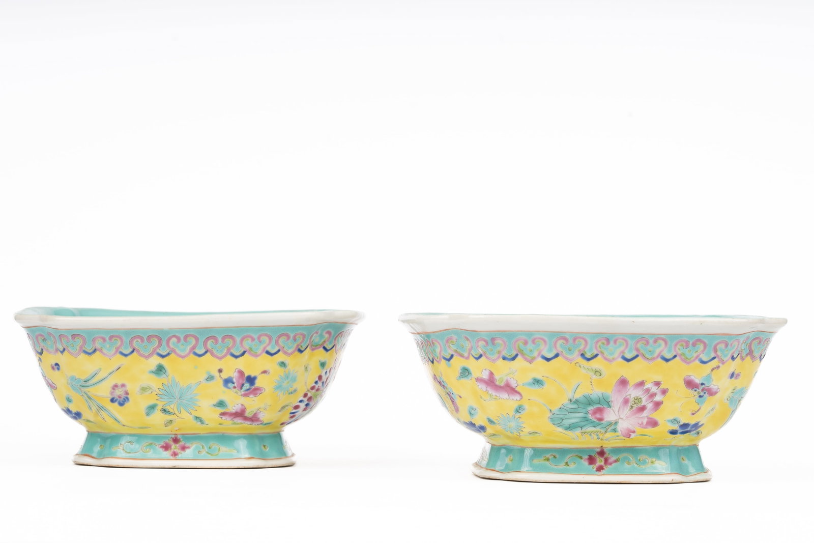 Pair of Chinese Famille Rose Bowls with Turquoise Glaze Interiors: Each porcelain bowl decorated to the exterior with famille rose lotus scrolls among foliage in bright enamels, the interiors finished in turquoise glaze now showing areas of wear. The bases bear apocr