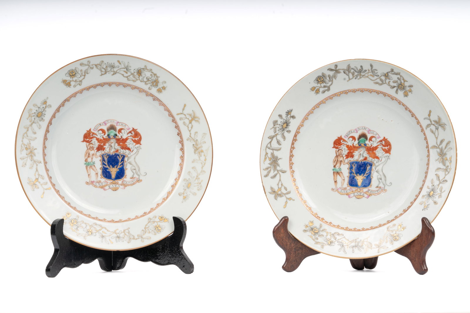 Pair of Chinese Export Armorial Porcelain Plates, MacKenzie Family: Each plate decorated in the center with the arms of MacKenzie, the blue shield with stag’s head crest, flanked by supporters including a lion and a nude figure, surmounted by a knight’s helm and p