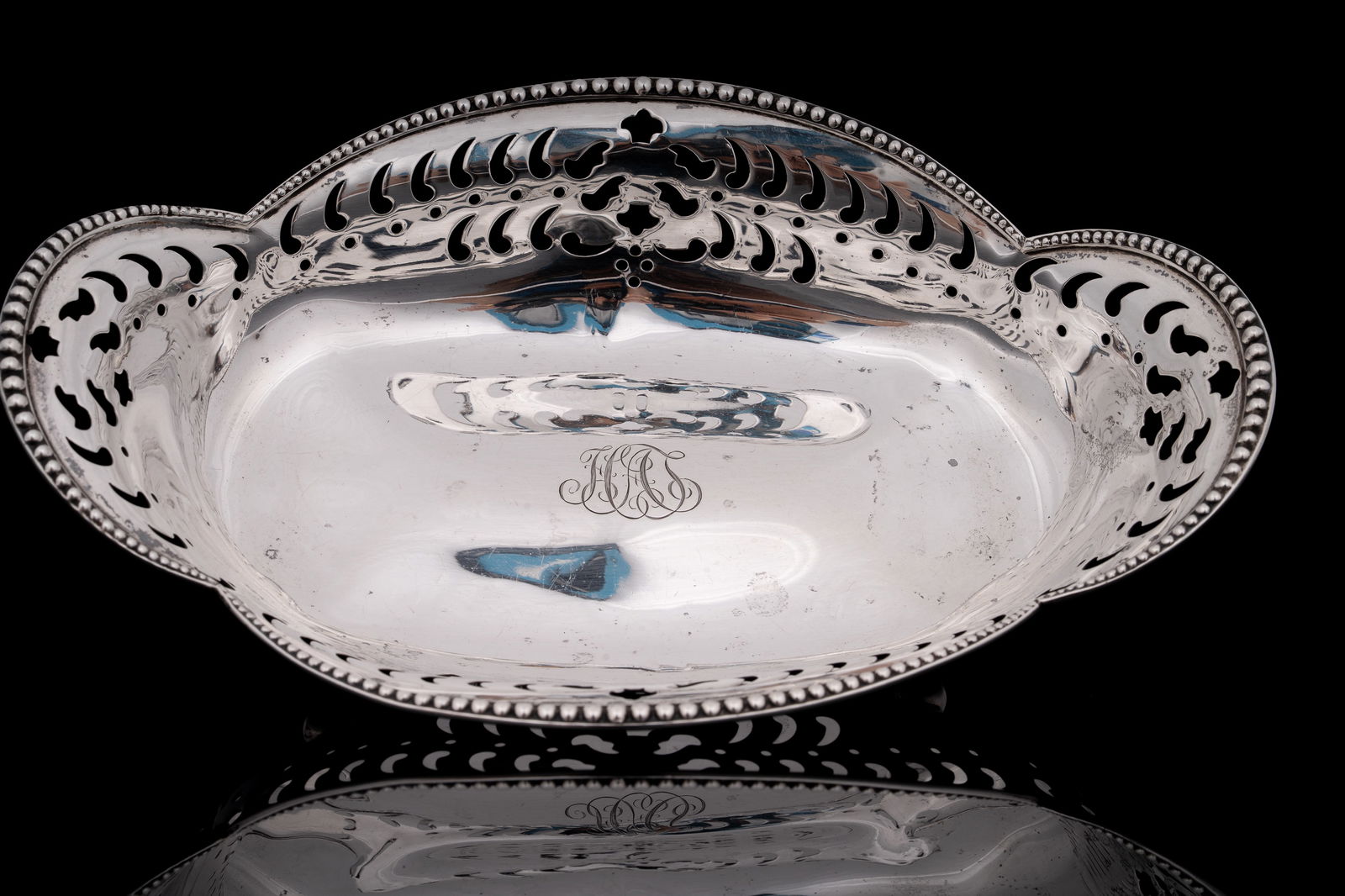 Tiffany & Co. Sterling Silver Reticulated Footed Bowl: Elegant sterling silver bowl by Tiffany & Co., featuring a reticulated design with pierced foliate and geometric motifs and raised on four rounded feet. The rim is edged with a beaded border, and the