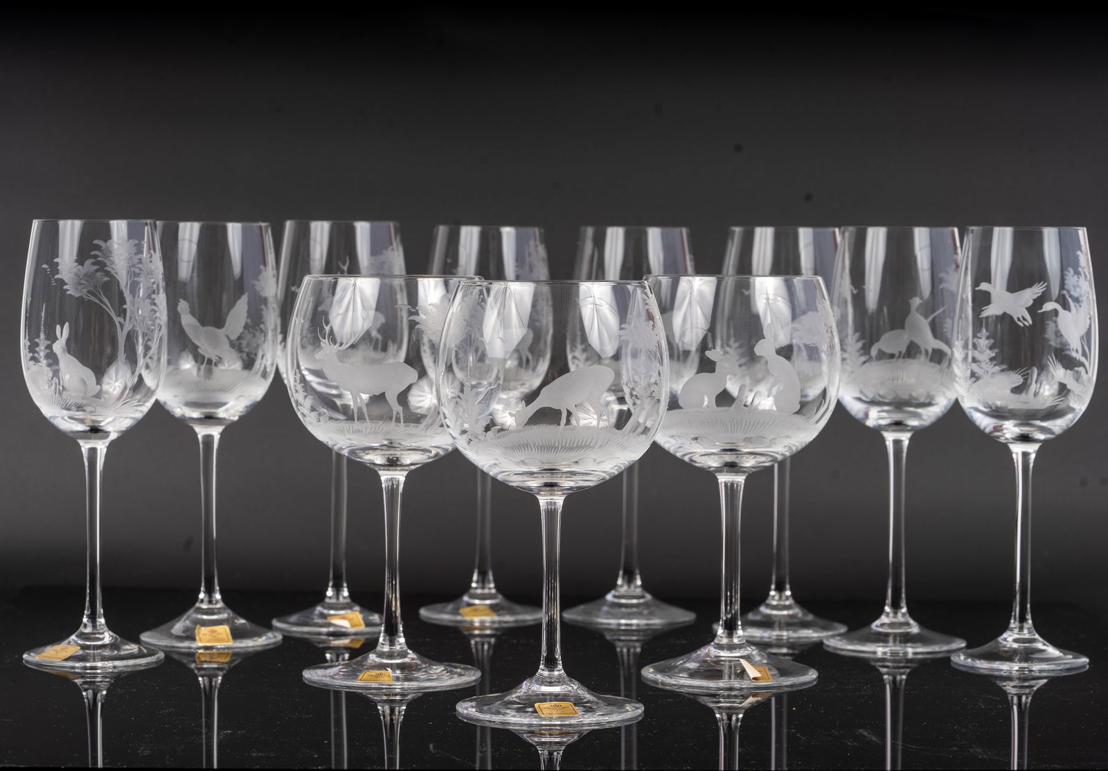 Theresienthal Etched Crystal Wine Goblets with Hunting Scene: A fine set of Theresienthal crystal wine goblets, each delicately etched with detailed hunting scenes featuring game animals such as deer, rabbits, and birds in wooded landscapes. Elegant long stems a