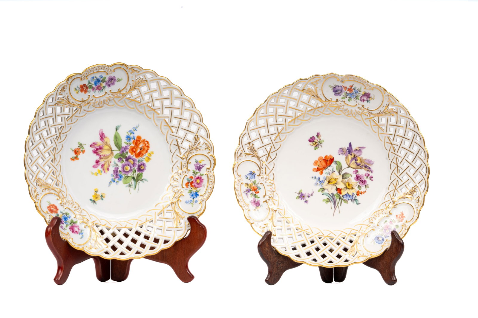 Pair of Meissen Reticulated Floral Cabinet Plates: A fine pair of Meissen porcelain cabinet plates, each hand-painted with colorful floral bouquets within gilt-edged reticulated lattice borders adorned with floral cartouches. Richly detailed and beaut