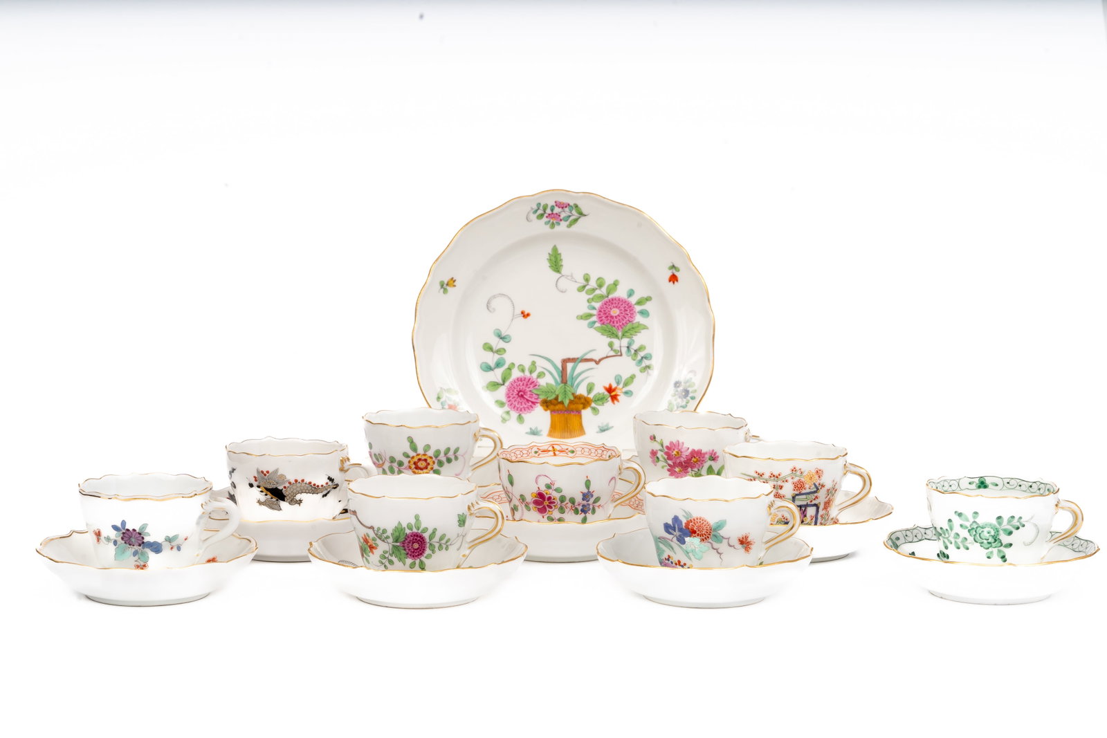 Set of Eight Meissen Demitasse Cups and Saucers, Various Patterns: A fine and diverse collection of eight Meissen porcelain demitasse cups and saucers, each hand-painted in a different classic pattern with gilt rims and scalloped edges. The group includes examples of