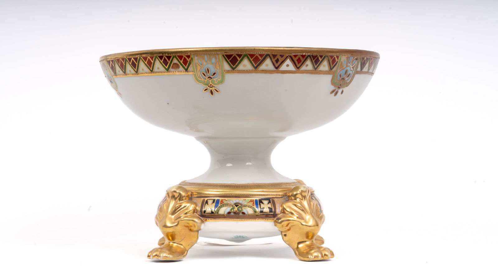 Nippon Hand-Painted Four-Footed Serving Bowl: Nippon porcelain serving bowl of circular form raised on four stylized paw feet, richly hand-painted in polychrome enamels and gilt. The interior and exterior borders are decorated with elaborate geom