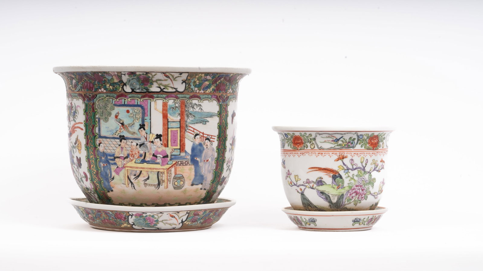 Pair of Chinese Famille Rose Planters with Saucers: A pair of Chinese porcelain famille rose planters, each of flared circular form with matching saucers, finely hand-painted in vibrant enamels depicting courtly and avian scenes. The larger example dec