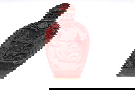 Chinese Carved Cinnabar Lacquer Snuff Bottle: Finely carved cinnabar lacquer snuff bottle depicting scholars and attendants in a landscape with pavilions and trees, surmounted by a domed stopper. The base fitted with a metal foot bearing an incis