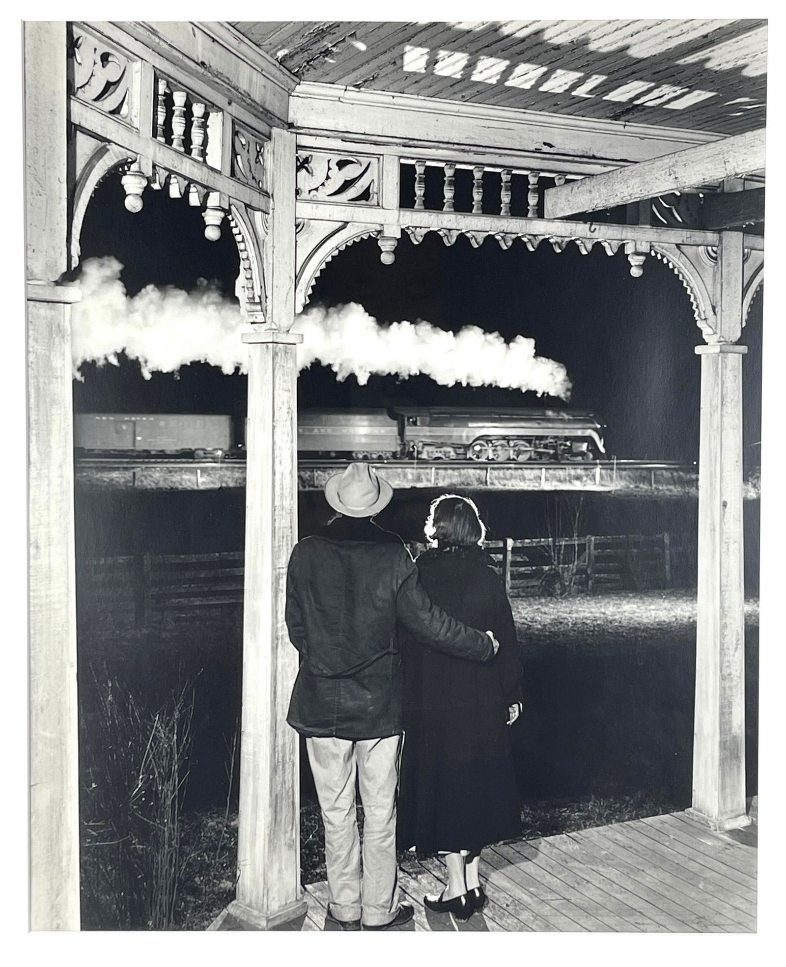O. Winston Link (America, 1914-2001), Mr. and Mrs. Pope watch the last...1957. Silver gelatin print: Mr. and Mrs. Pope watch the last steam powered passenger train, Max Meadows, Virginia., 1957 silver gelatin print by O. Winston Link. Print not examined out of the frame. Mat opening: 19 1/8” x
