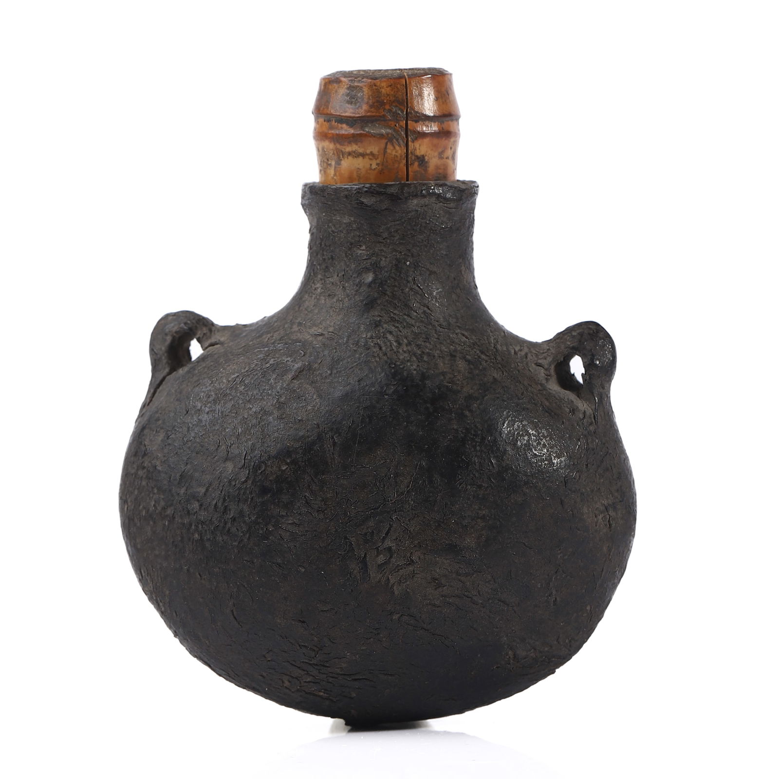 A BLACK CLAY MEDICINE FLASK, INCISED WITH THE CHARACTER “GUAN: Dimensions Height: 3 1/2 in (9 cm) Description A traditional hard-paste black clay medicine flask of rounded compressed form, the surface exhibiting a dense, textured finish characteristic of kiln-fir