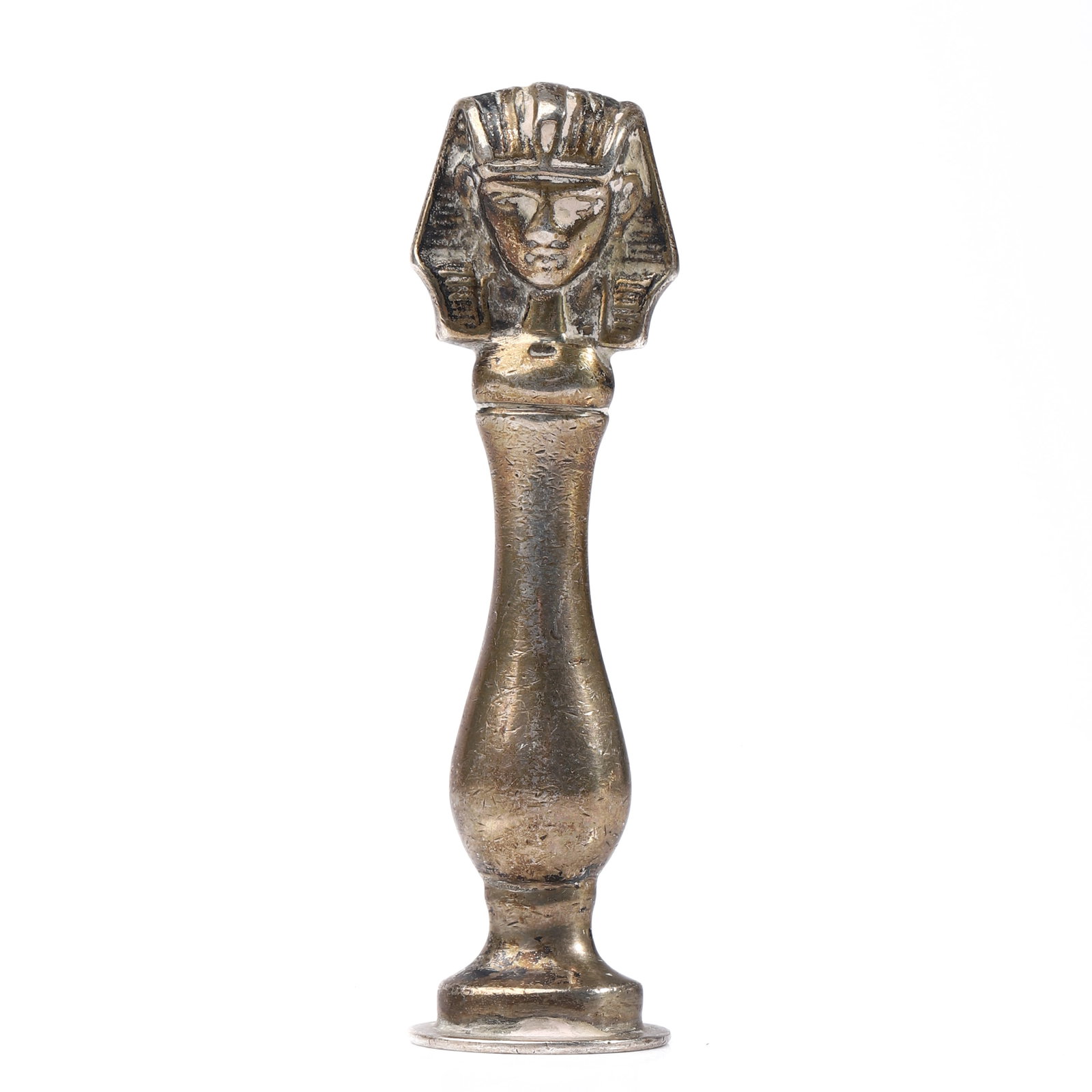 A BRONZE EGYPTIAN-STYLE FIGURAL SEAL: Dimensions Height 2 13/16 in (7.2 cm); Weight 32.3 g. Description A bronze seal topped with an Egyptian-style head, reminiscent of a pharaonic headdress, set on a slender baluster-shaped handle and ci
