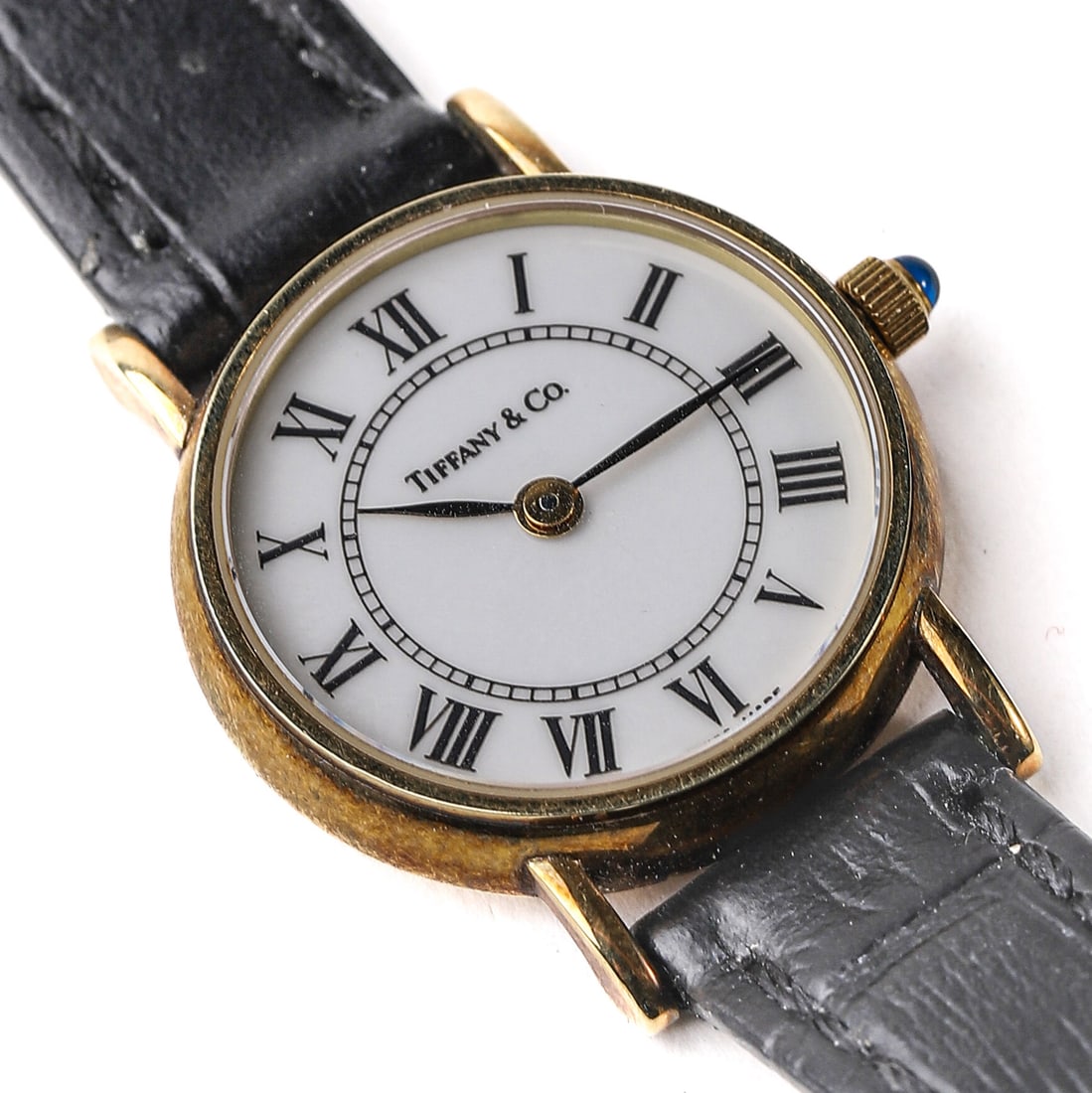 TIFFANY & CO. 14K GOLD WRISTWATCH: This Elegant Timepiece From Tiffany & Co. Showcases A Classic Design With A 14-Karat Gold Case And A White Dial Featuring Roman Numerals. The Watch Face Measures 25/32 In. (20 Mm) In Diameter,