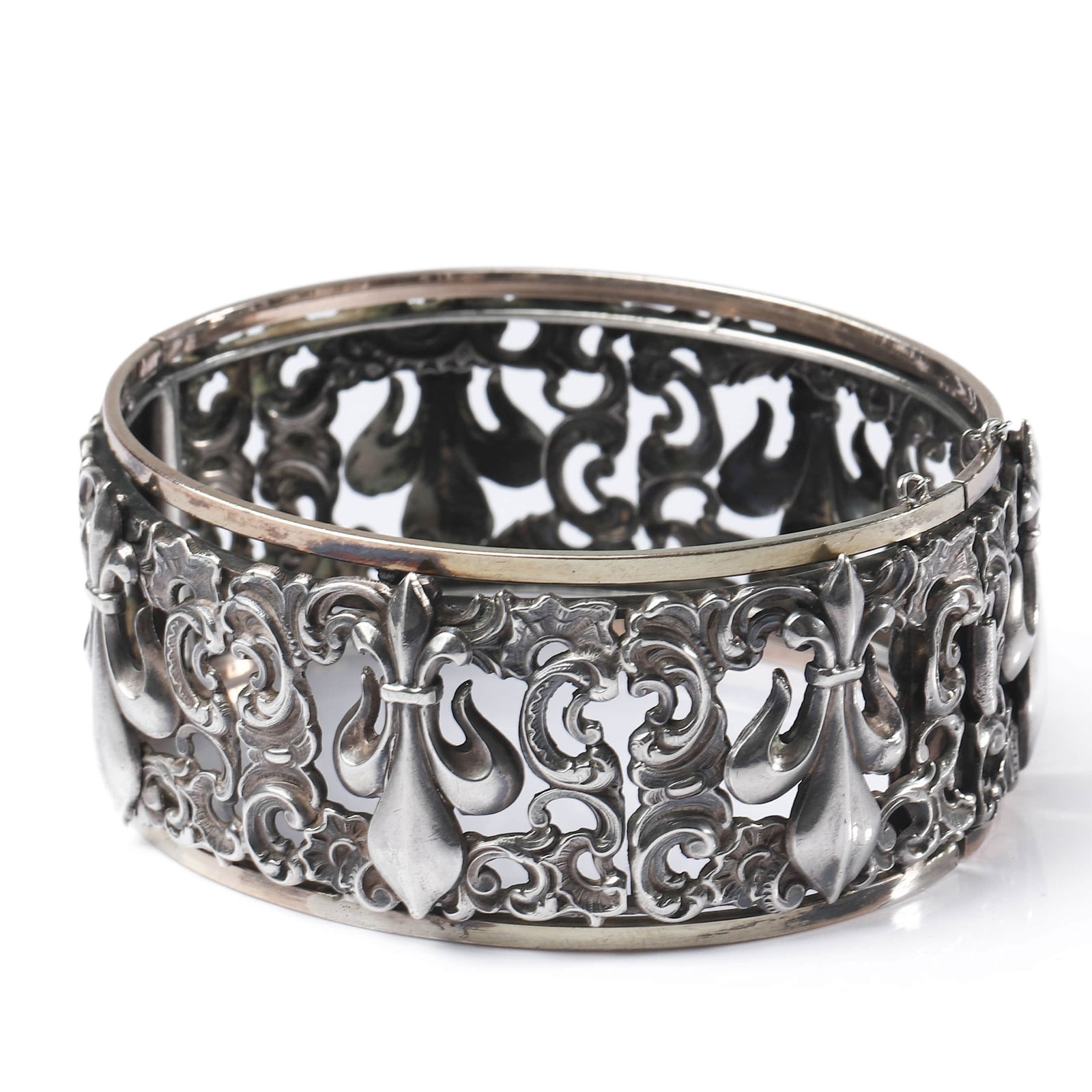 ART NOUVEAU IRIS MOTIF GOLD AND SILVER BRACELET: Dimensions Inner diameter adjustable approx. 2 1/8–2 7/16 in. (53–62 mm); Weight: 41.3 g. Description An elegant Art Nouveau bracelet finely executed in silver and gold, featuring a high-relief