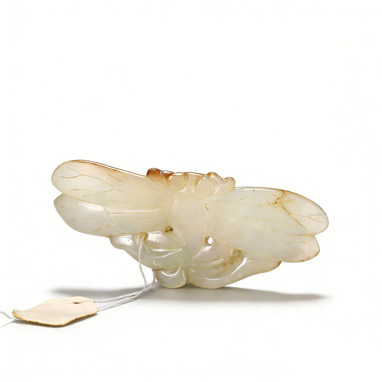 A Fine Qing White Jade Pendant with Russet Skin Carving of a Dragonfly: L:8.5cm W:3.7cm This exquisite pendant is masterfully carved from a single piece of white jade, retaining natural russet skin inclusions that are artistically integrated into the design. It