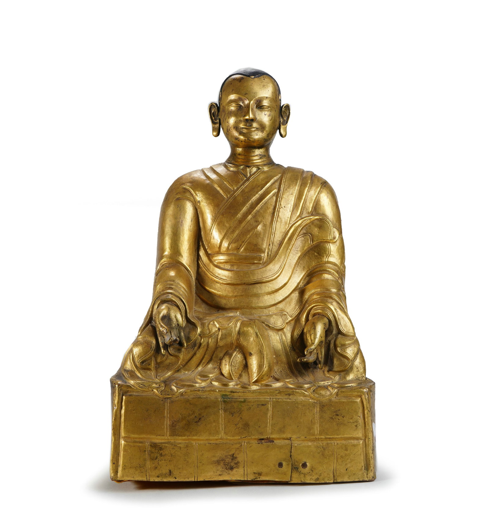 Gilt - bronze Seated Statue of Guru: H:38cm W:23cm This gilt - bronze seated statue of a guru takes copper as the body and is fully gilded. The guru sits cross - legged, has a peaceful face, wears a kasaya, and the depiction of the garme