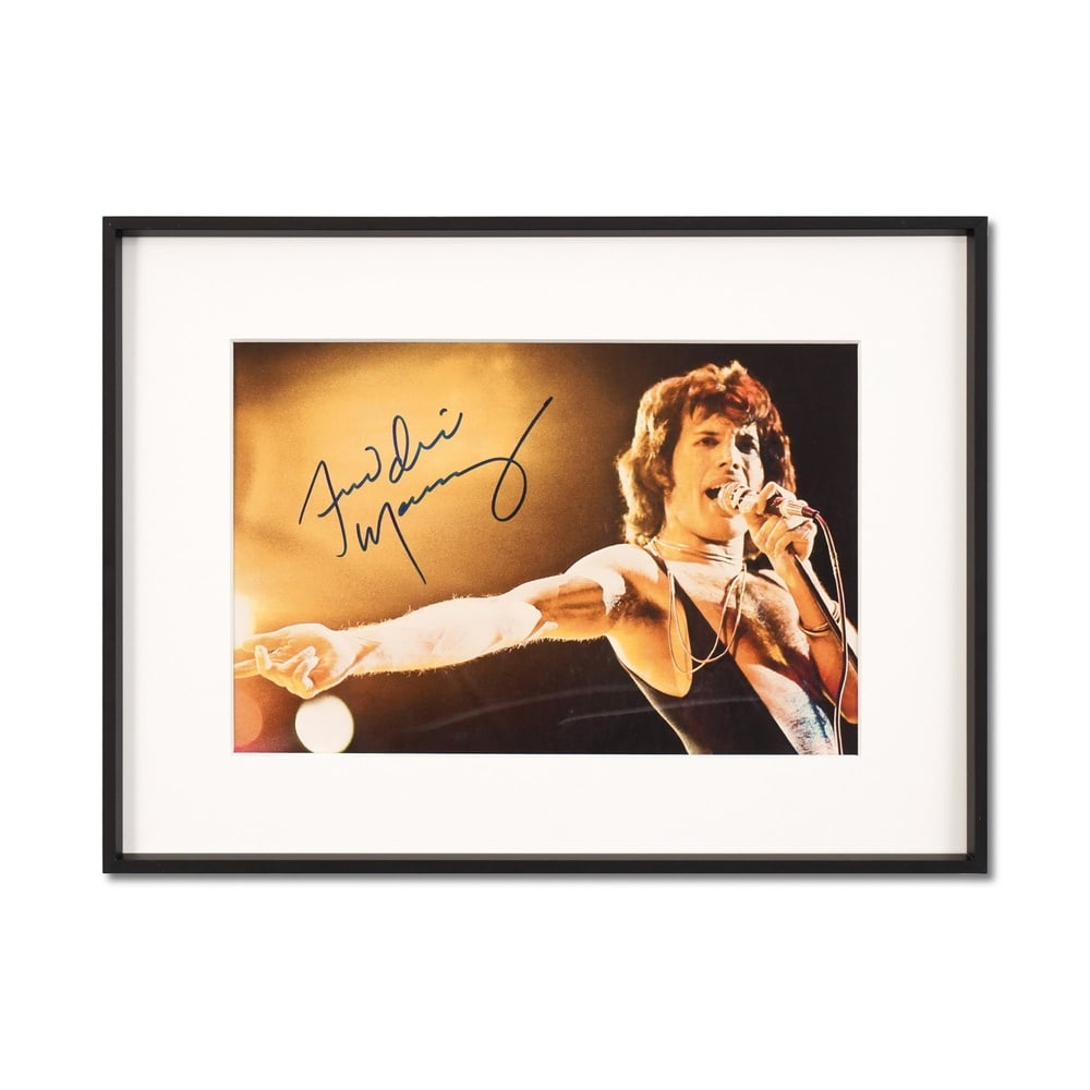 FREDDIE MERCURY SIGNED PHOTOGRAPH: Image Dimensions: 11 1/2 x 7 5/8 in (29.3 x 19.2 cm) Framed Dimensions: 16 3/8 x 12 1/8 in (41.5 x 30.7 cm) This signed photograph captures Freddie Mercury at the height of his artistic power,