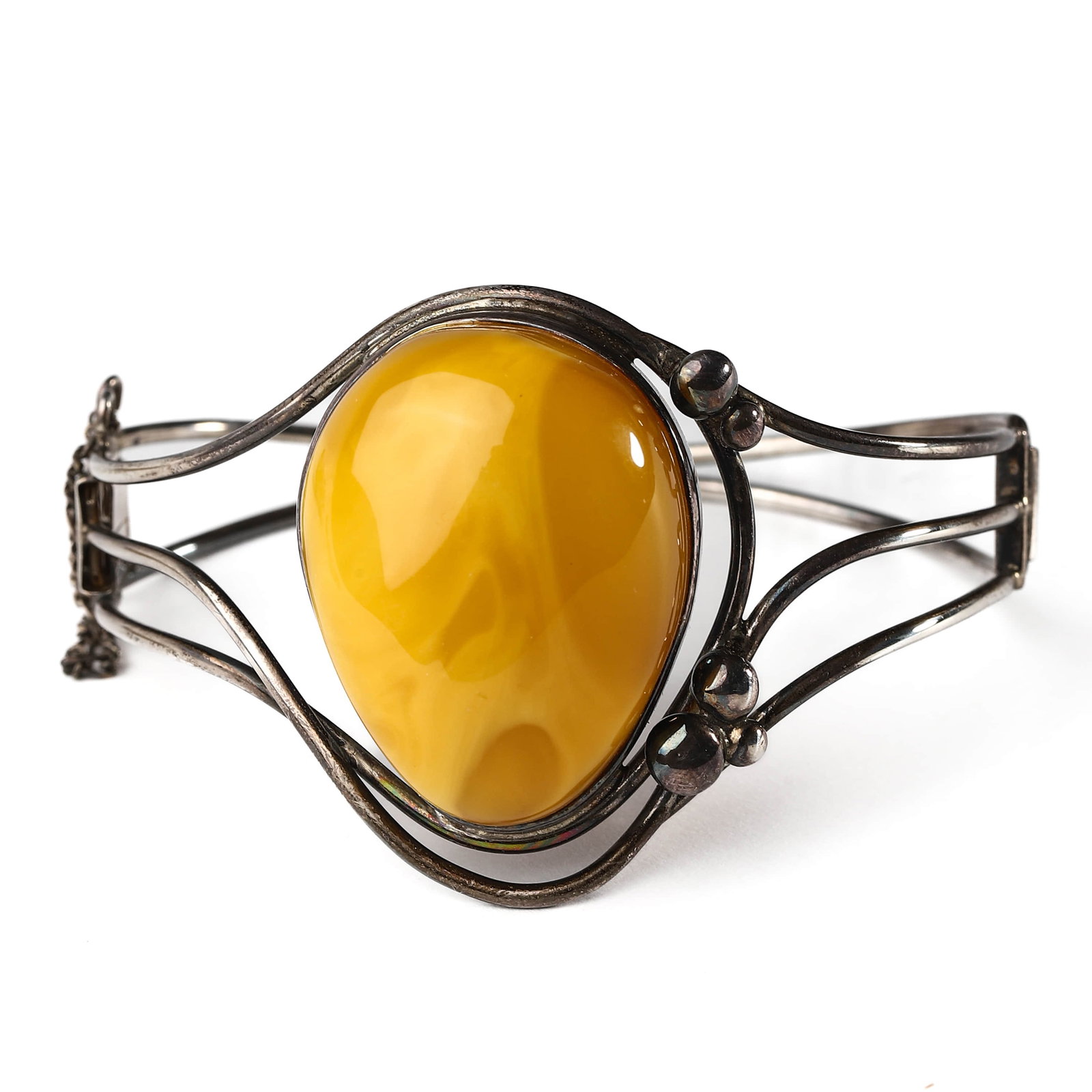 BALTIC AMBER AND SILVER BRACELET: DIMENSIONS: Inner diameter: 2 1/2 in. (63 mm), Amber: 1 5/16 × 1 1/16 in. (33.6 × 26.5 mm), Weight: 20.5 g DESCRIPTION: A vintage silver bracelet featuring a large, polished cabochon of Baltic