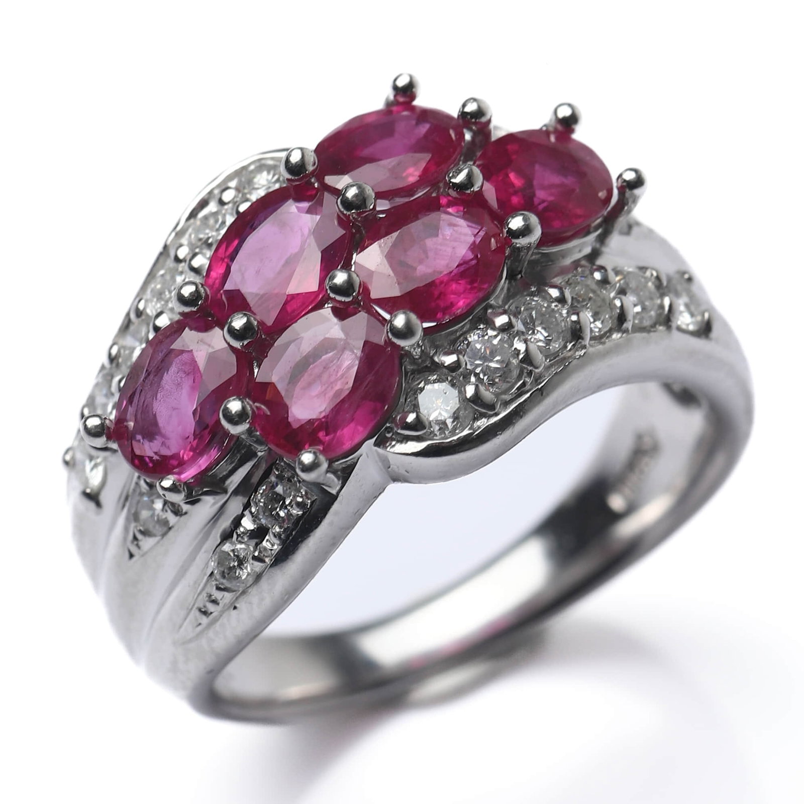 PLATINUM RUBY AND DIAMOND RING: Dimensions Inner diameter: 21/32 in (16.9 mm); Weight: 10.4 g Description This elegant ring is crafted in platinum and set with a cluster of oval-cut rubies forming a raised, rounded crown at the