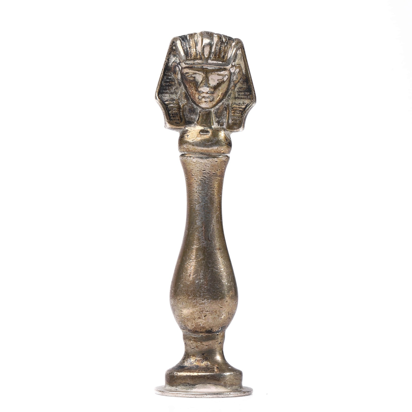 A BRONZE EGYPTIAN-STYLE FIGURAL SEAL: Dimensions Height 2 13/16 in (7.2 cm); Weight 32.3 g. Description A bronze seal topped with an Egyptian-style head, reminiscent of a pharaonic headdress, set on a slender baluster-shaped handle and