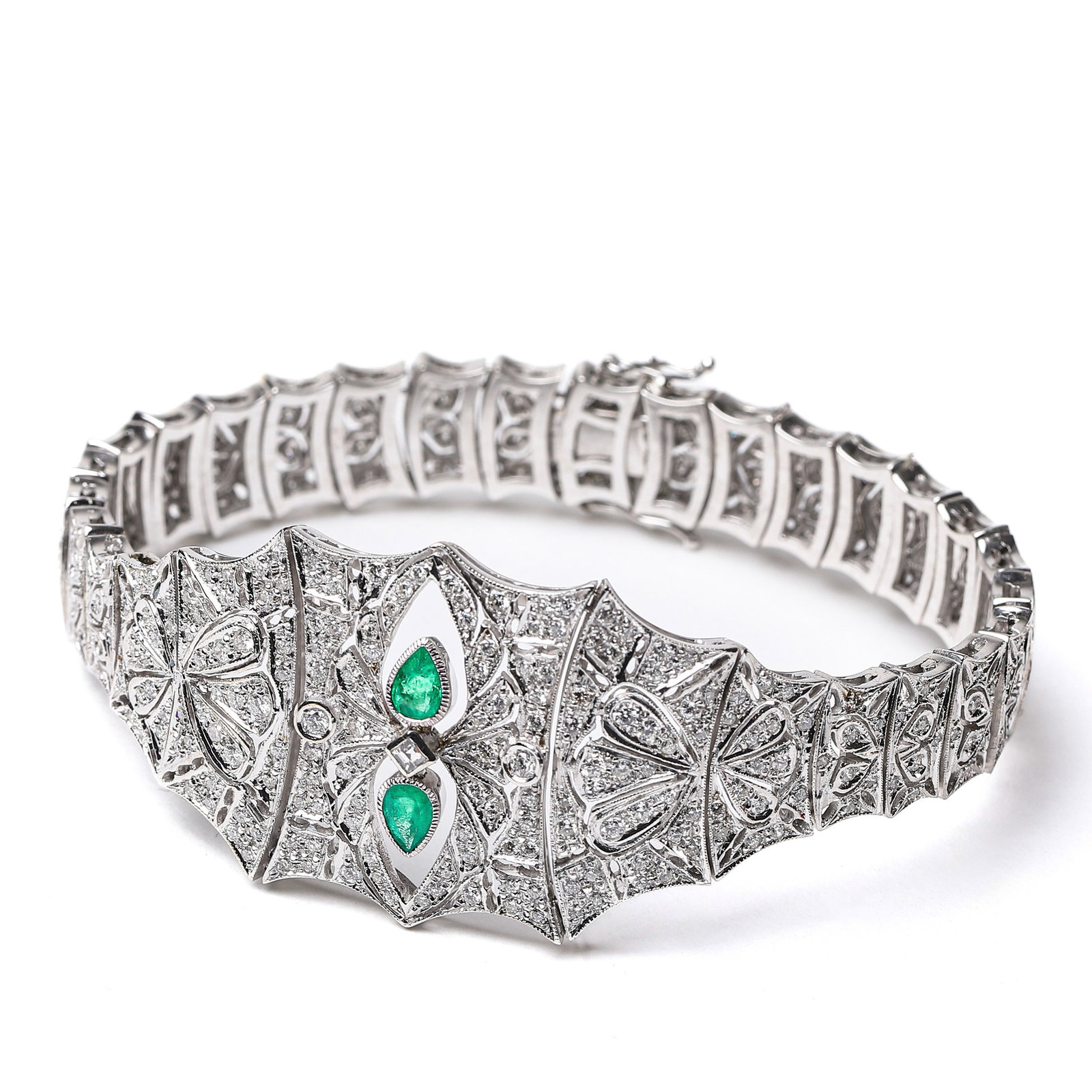 ART DECO ITALIAN CUSTOM 18K GOLD BRACELET SET WITH DIAMONDS AND EMERALDS, 1925-1935.: Dimensions: Length: 7 1/2 in (19 cm); Weight: 37.7 g; Period: 1925-1935.This custom-made bracelet is meticulously crafted from 18k white gold, featuring the iconic beaded edge detailing of the Art