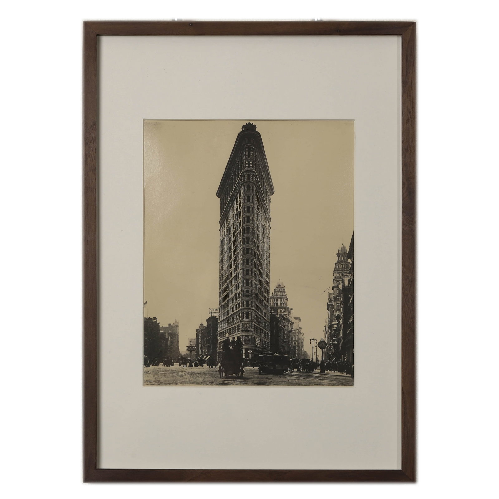 NEW YORK CITY, THE FLATIRON BUILDING, CIRCA 1900S–1910S: Flatiron Building, New York, circa 1904 Gelatin silver print (later printed) Dimensions: Image 6 7/8 × 8 5/8 in. (17.6 × 22 cm); Frame 11 × 15 3/8 in. (28 × 39 cm) Description: An evocative gelati