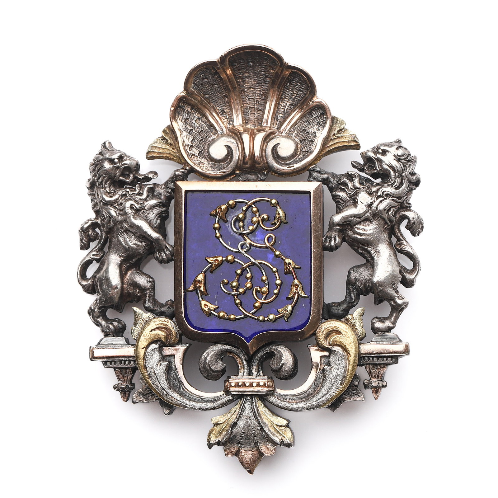 A SILVER, GOLD AND ENAMEL HERALDIC BROOCH: Dimensions Length: 2 in (5 cm); Width: 2 3/8 in (6 cm); Weight: 55.3 g Description The brooch is finely crafted in silver, accented with gilded highlights, and centered with a cobalt blue enamel shiel