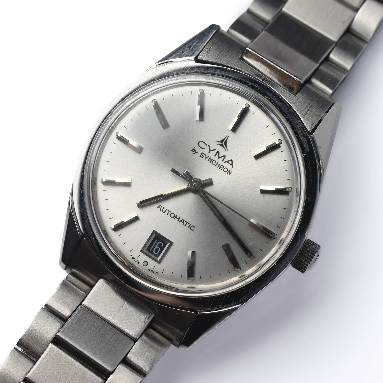 CYMA BY SYNCHRON AUTOMATIC STAINLESS STEEL WRISTWATCH: Dimensions Dial diameter: 1 7/16 in. (36 mm) Description A Cyma by Synchron automatic wristwatch featuring a brushed silver-tone dial with applied baton hour markers and central date aperture at 6 o��