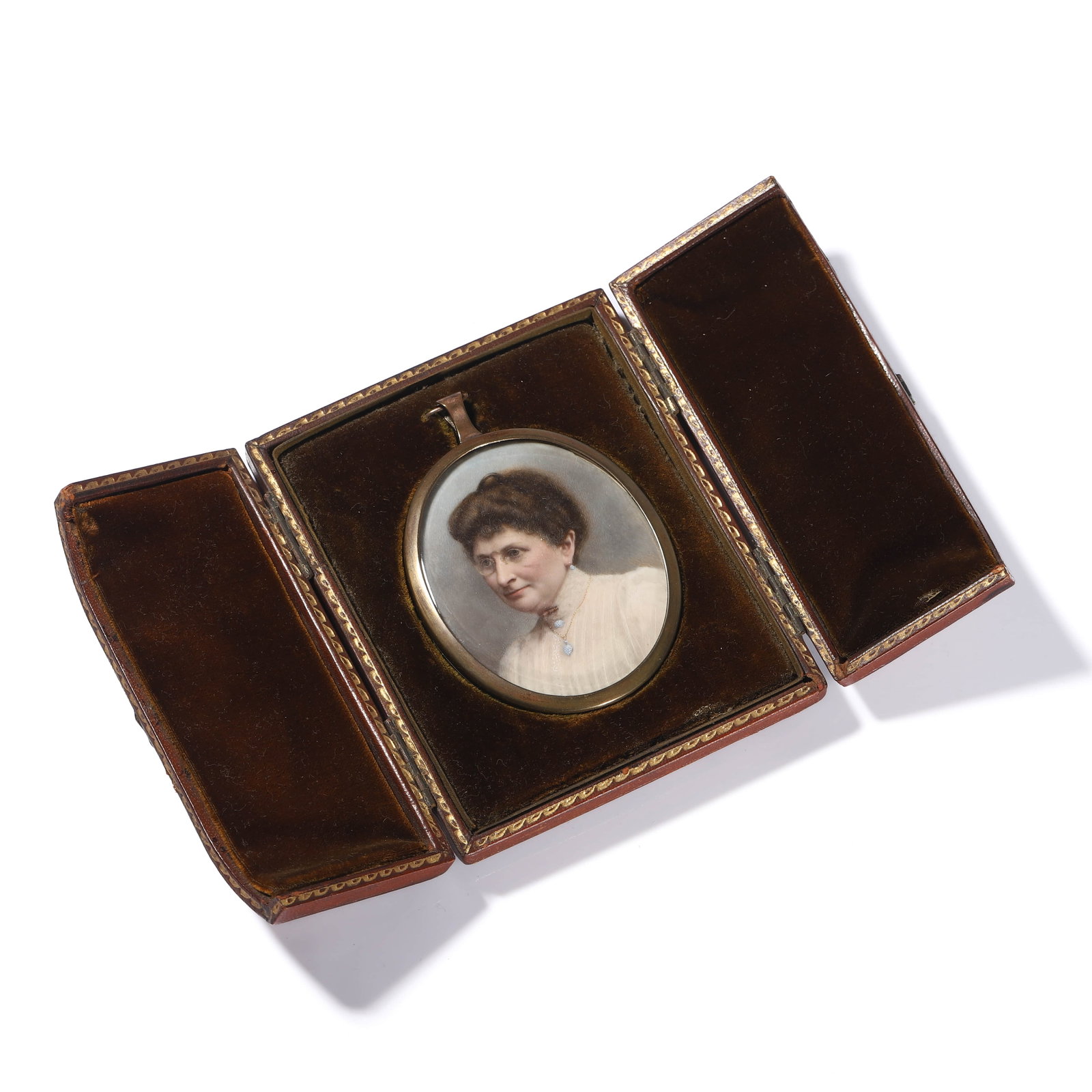 BRITISH SCHOOL, CIRCA 1900 — PORTRAIT OF A LADY WITH PINCENEZ AND TURQUOISE JEWELRY.: BRITISH SCHOOL, CIRCA 1900 — PORTRAIT OF A LADY WITH PINCENEZ AND TURQUOISE JEWELRY. Medium: Watercolor on ivory, mounted under curved glass within a brass frame of rose-gold patina, presented in
