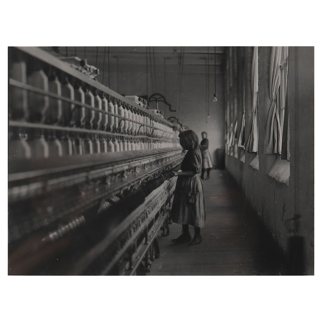 LEWIS WICKES HINE (1874–1940) GIRL WORKING IN A CAROLINA COTTON MILL: Artist LEWIS W. HINE Title: GIRL WORKING IN A CAROLINA COTTON MILL Date: 1908 Material: Gelatin silver print, mounted on board Signature/Mark: Stamp on the reverse Dimensions Photograph 4 3/4 × 6