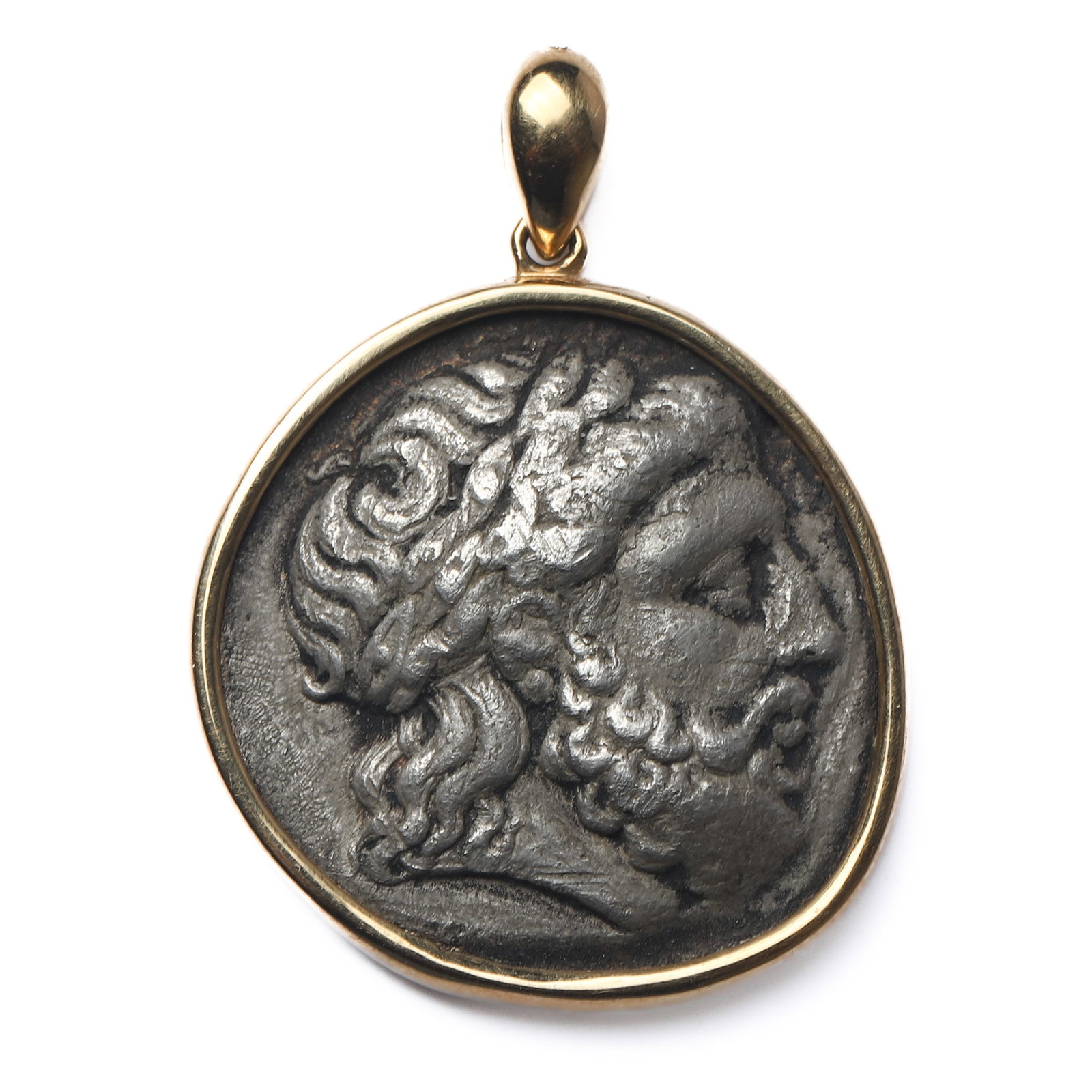 AN ANCIENT GREEK SILVER COIN PENDANT OF ZEUS AND KING PHILIP II, SET IN 18K GOLD: Dimensions Height: 1 3/8 in. (3.5 cm), Width: 1 in. (2.6 cm)Weight: 17 g Description An antique pendant set with an ancient Greek silver coin, the obverse depicting a laureate head of Zeus rendered