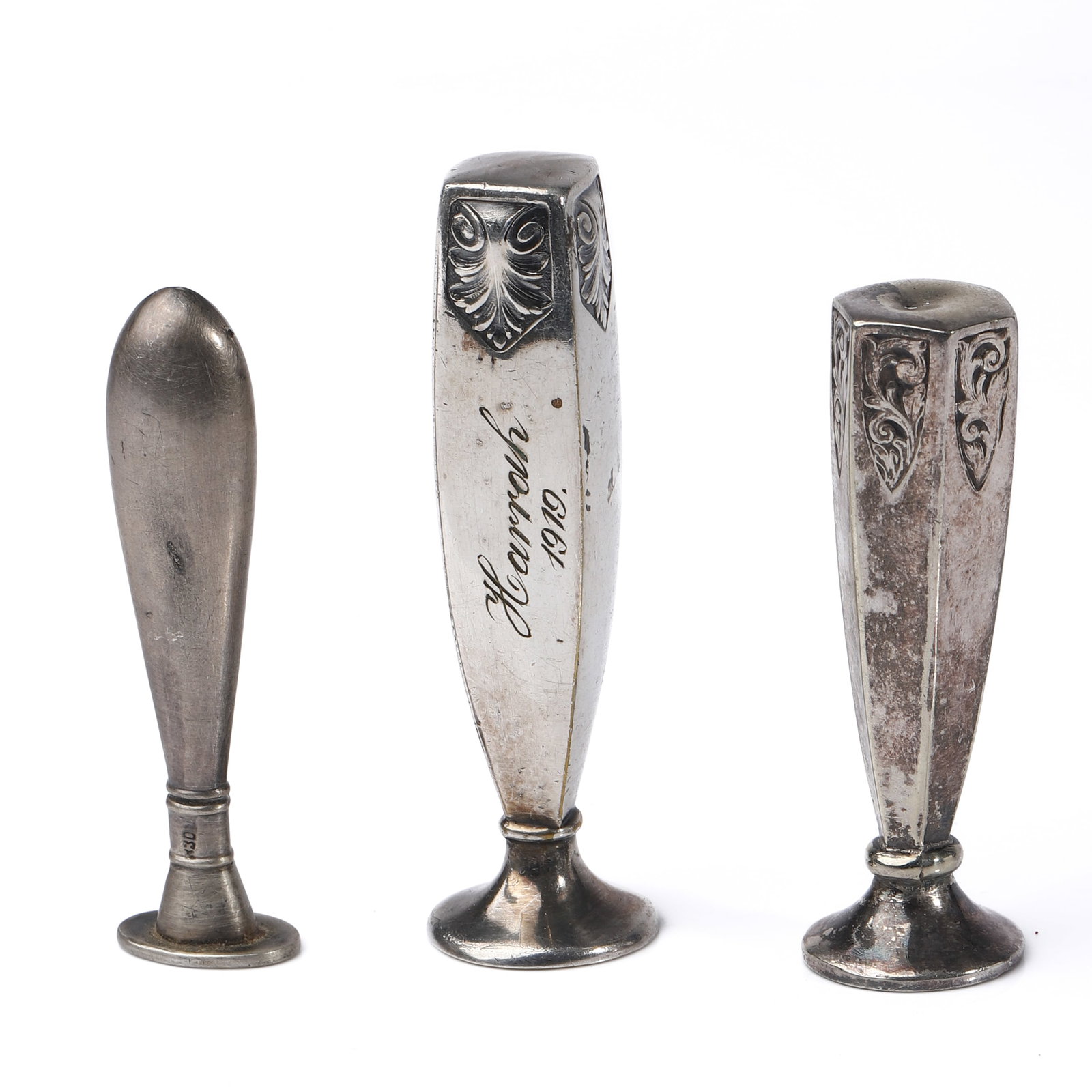 A GROUP OF THREE METAL WAX SEAL STAMPS: Dimensions: Tallest: 2 13/16 in (7.2 cm) Shortest: 2 3/8 in (6.1 cm) Total weight: 44.4 g Description: A group of three early 20th-century metal wax seal stamps featuring varied forms and engraved